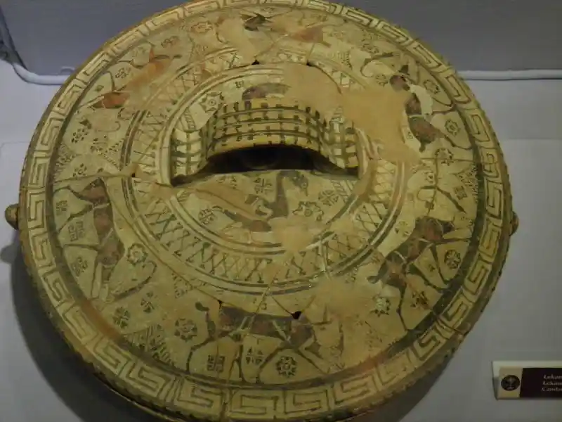 Different designs of crosses, solar discs and swastikas, and goats and birds painted on a lid, located at Archaeological Museum of Izmi
